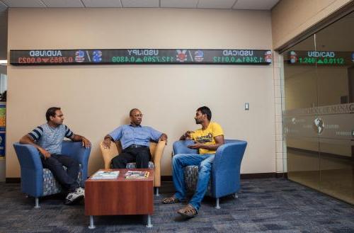 Graduate students discuss latest business trends with a faculty member in the School of Management.